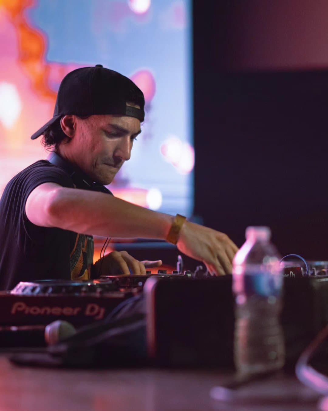 A DJ in a cap working the decks at Revolution Live